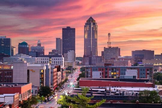 The Des Moines skyline under a warm pink and orange sunset